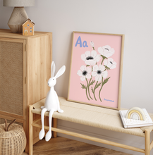 Load image into Gallery viewer, White rabbit toy on a wooden bench with a framed Anemone floral print on pink and decorative items.